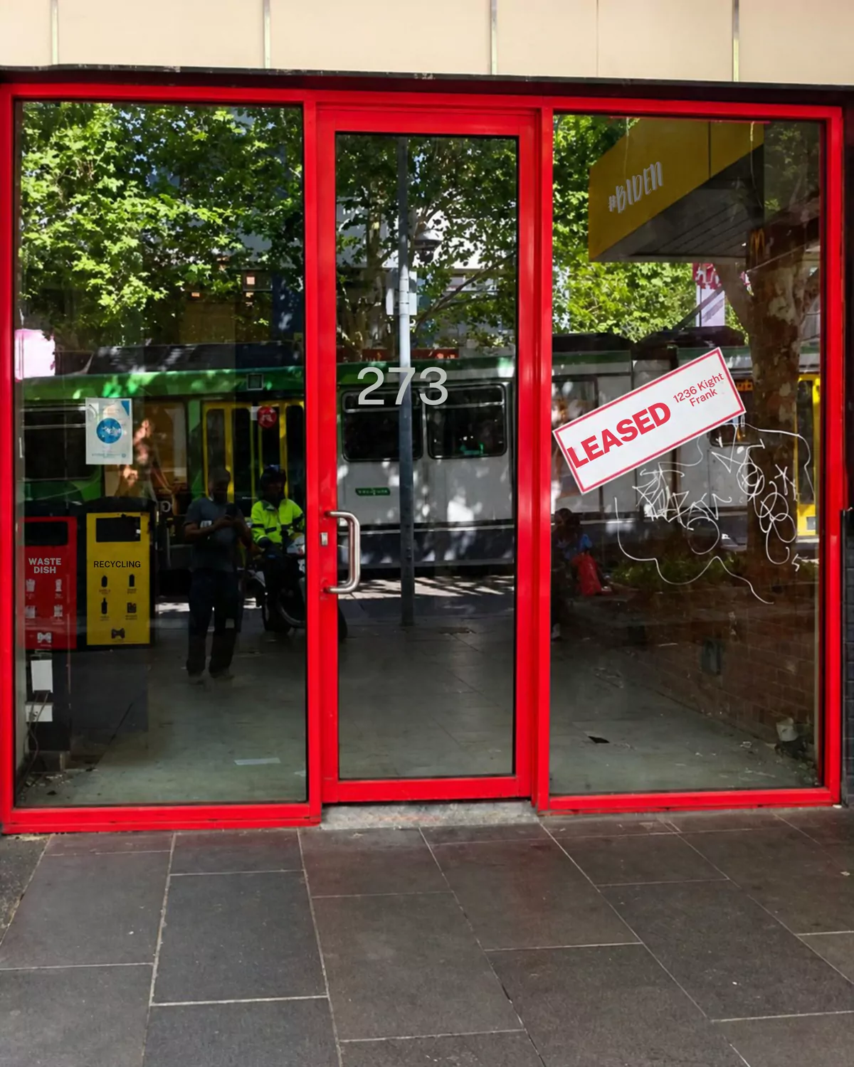 Before: a city shopfront with faded red aluminium frames, a leased sign and graffiti on the glass